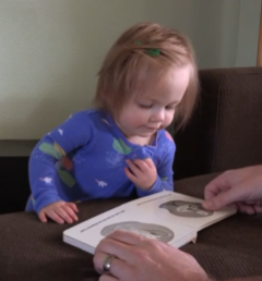 Child intensely looking at monochromatic board book page